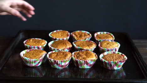 chef take away cupcake from baking tray. cooked cupcakes on baking pan