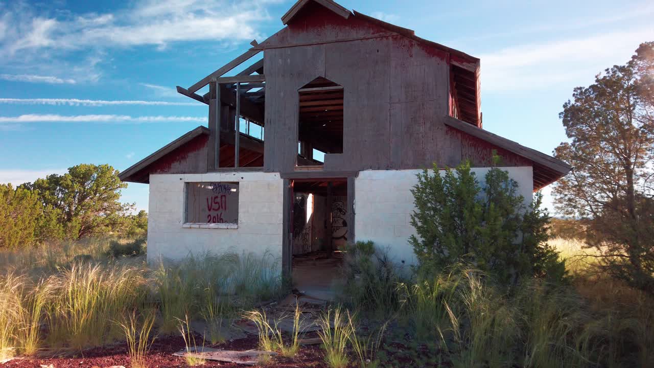 Wide static shot of a rundown desert barn