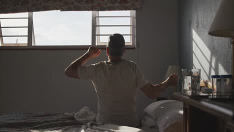 senior man lying on bed at home