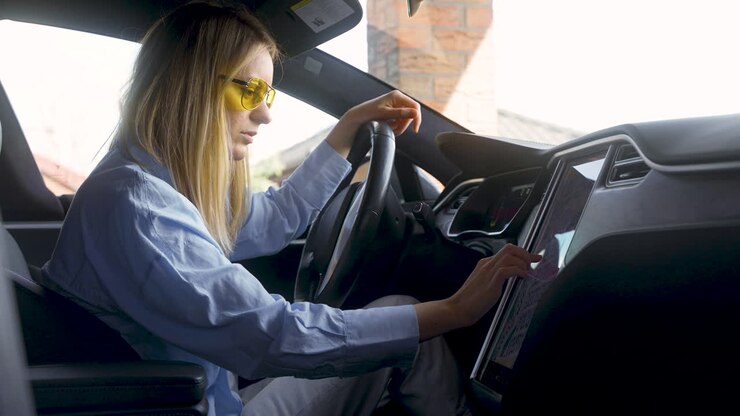 Donna bionda seduta su un'auto elettrica