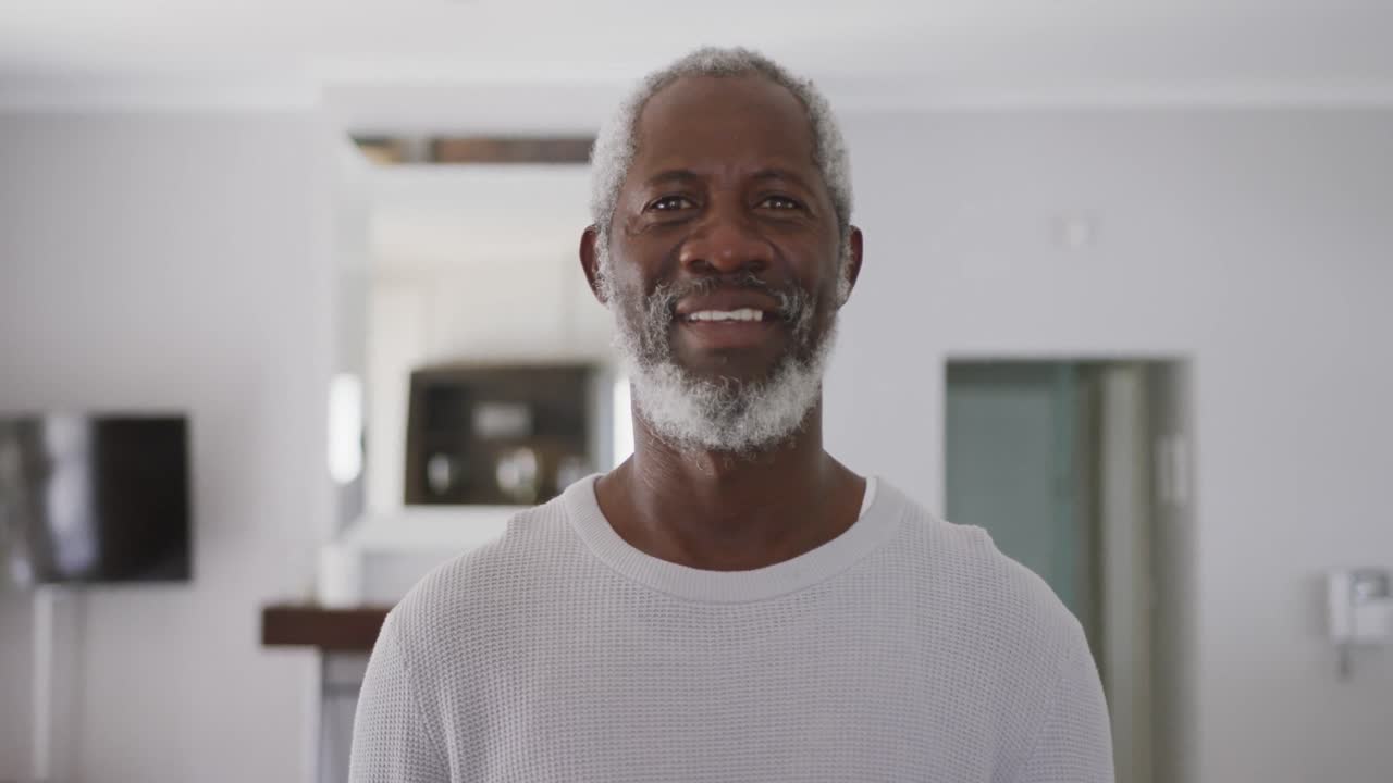 A senior African american man smiling at the camera in social distancing