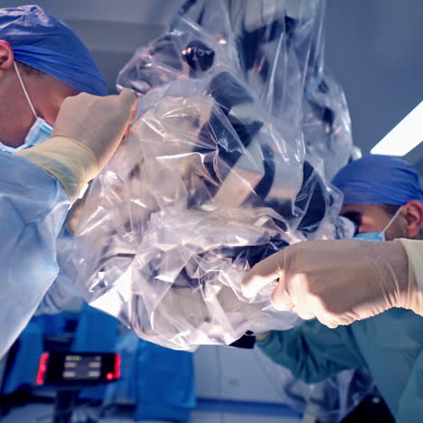 neurourgeons are operating with medical robotic surgery machine. manual control by minimally invasive surgical system. modern automated medical device. surgical room in hospital with robotic technology equipment, machine arm neurosurgeon. closeup of neurosurgery machine.