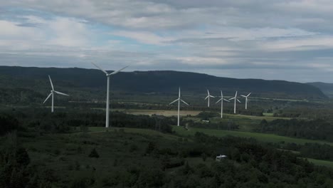 turbinas de viento en una fila en un paisaje de campo escénico bajo un cielo nublado en san lorenzo, quebec, canadá