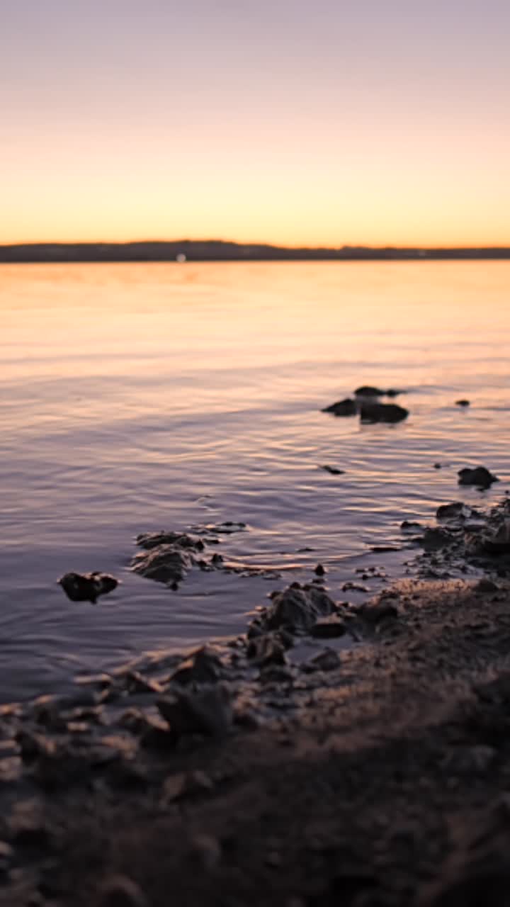 Tranquil Sunset or Sunrise Over Water with Rocky Shoreline