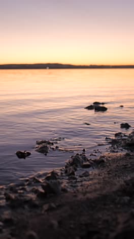 tranquil sunset or sunrise over water with rocky shoreline