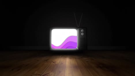 Purple-abstract-shapes-on-television-screen-over-wooden-surface-against-black-background