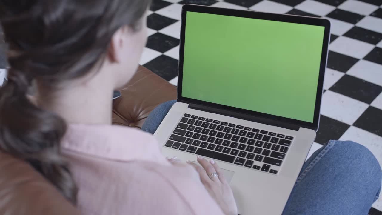 mujer usando una computadora portátil con pantalla verde
