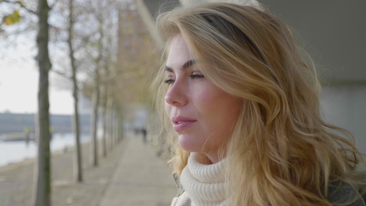 Nærbillede af ung blond kvinde fordybet i tanker.