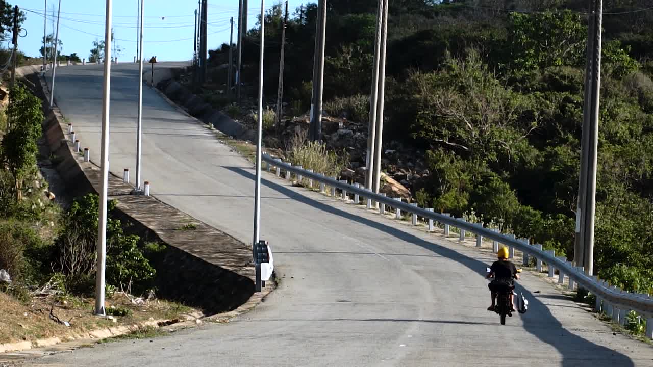 surfista en motocicleta viaja por la carretera a través de las selvas costeras de vietnam