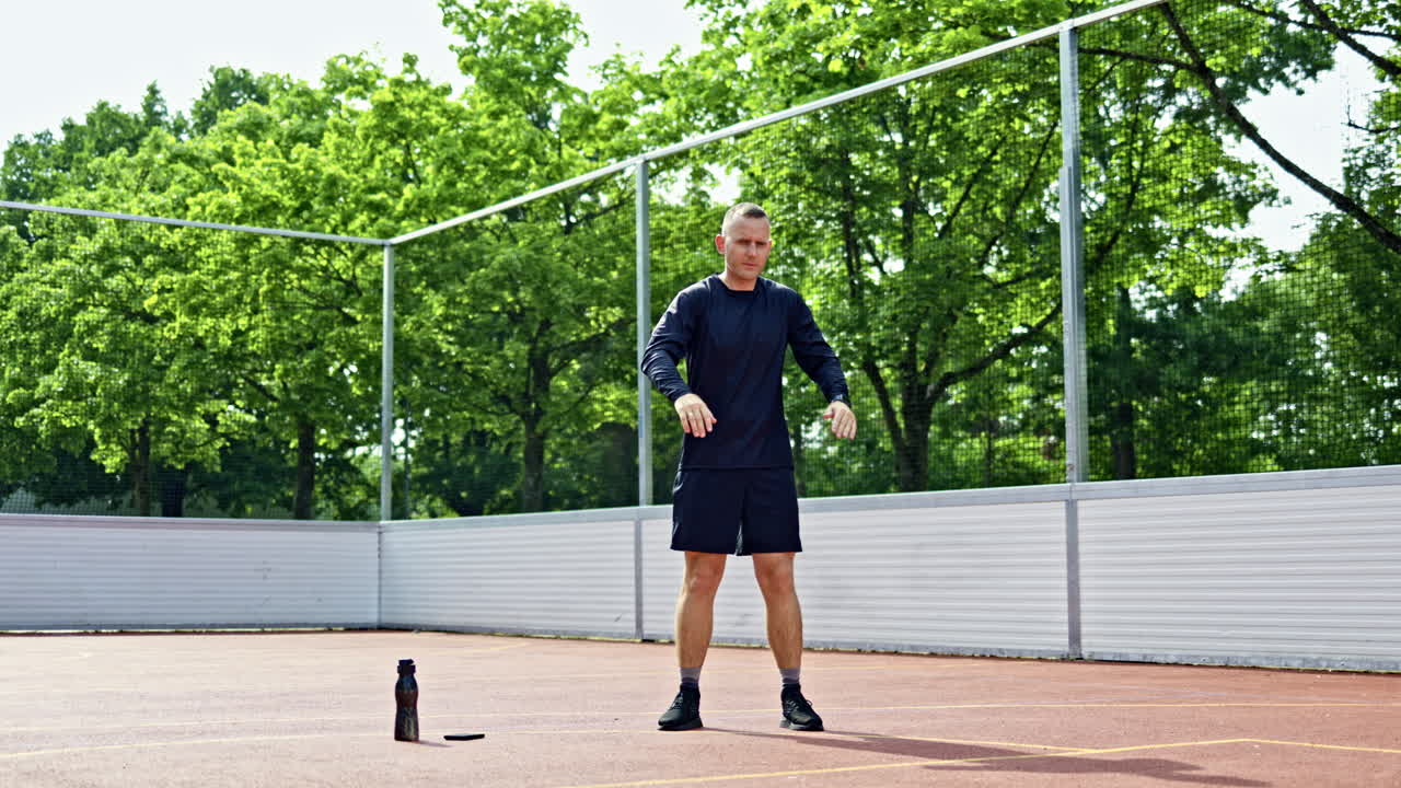 Mladý pohledný muž v černých šortkách cvičí na sportovišti. Muž sportuje venku v městském parku. Zdravý životní styl.