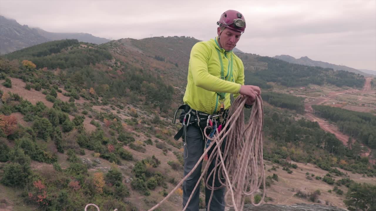 escalador recogiendo una cuerda. equipo de escalada. deporte extremo