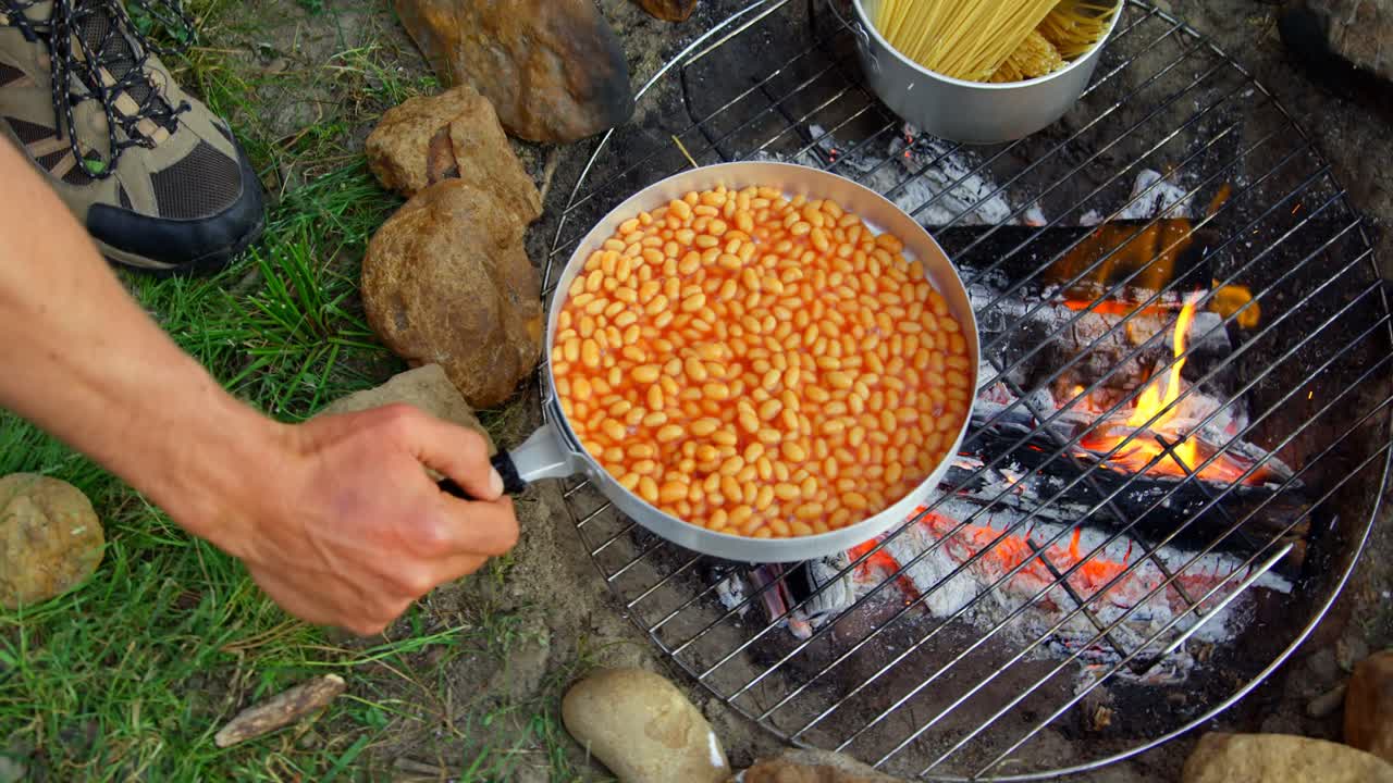 hombres preparando comida en el fuego del campamento en el bosque 4k