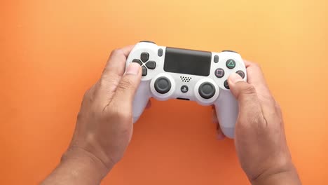 persona que sostiene un controlador de playstation blanco