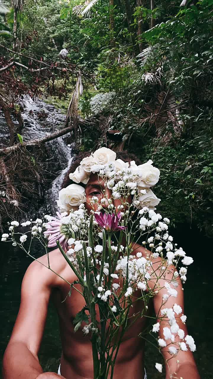 hombre con flores en un bosque de cascadas