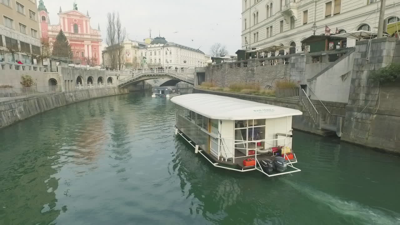 Little touristic boat cruise on its usual route over river Ljubljanica in Ljubljana, Slovenia