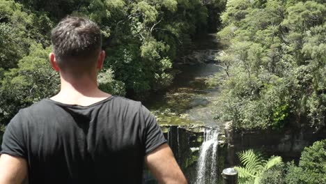 Joven-Caucásico-Desde-Atrás-Mirando-Las-Cataratas-De-Mokoroa,-Auckland,-Nueva-Zelanda