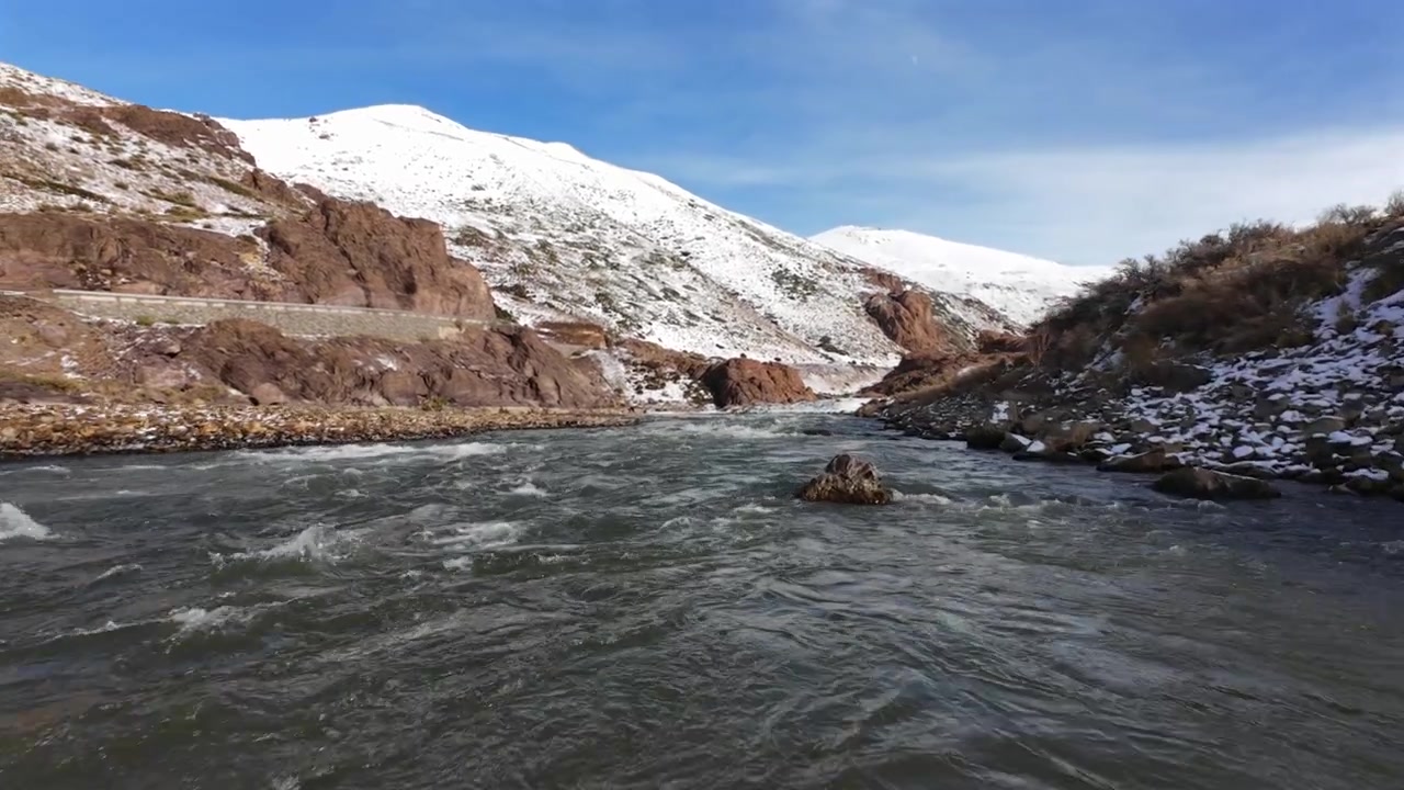 Sông Río Grande chảy qua địa hình Andes phủ tuyết gần Quốc lộ 145 ở Paso Pehuenche, Tỉnh Mendoza, Argentina, cảnh quay FPV bay thấp trên sông theo dòng nước núi chảy xiết
