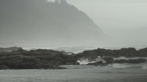 Low-telephoto-shot-of-ocean-shore-with-mountains-in-the-background