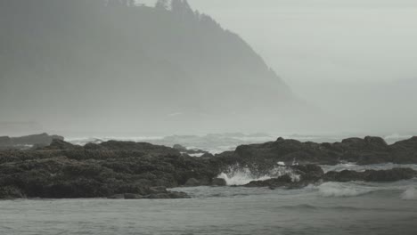 disparo de teleobjetivo bajo de la costa del océano con montañas en el fondo