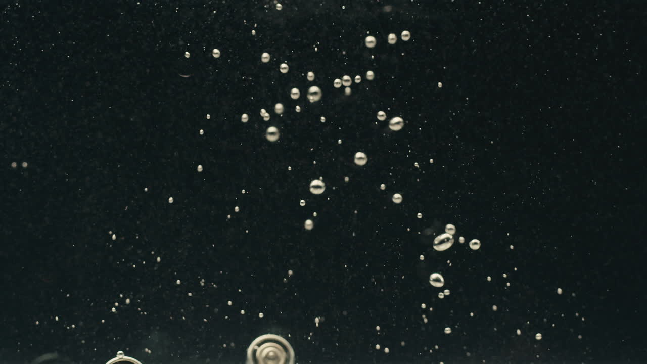 Silver batteries AA and AAA falling into water close-up. Double-A battery is a standard size single cell cylindrical dry battery. Batteries are common in portable electronic devices. Environmental impacts of lithium-ion batteries concept. An AA battery is composed of a single electrochemical cell th