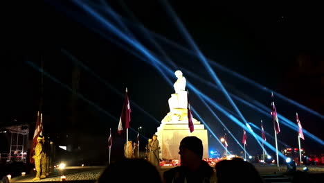 lāčplēsis day night celebration with monument lit by vibrant beams and latvian flags in jelgava