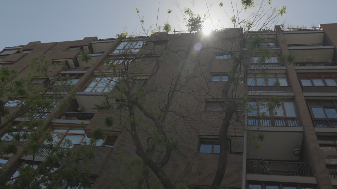 edificio de apartamentos madrid living con sol brillando detrás, vista en movimiento