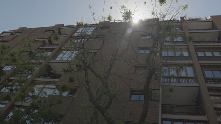 Edificio residenziale a Madrid con il sole che splende dietro, vista in movimento.