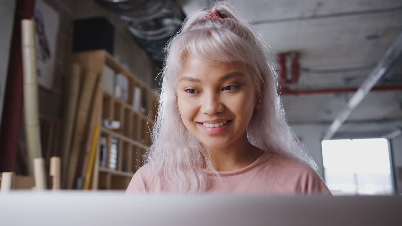 primer plano de una propietaria de un negocio en un taller de bicicletas sostenibles haciendo cuentas en una computadora portátil
