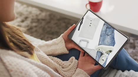 mujer caucásica usando una tableta en casa para comprar en línea, cámara lenta