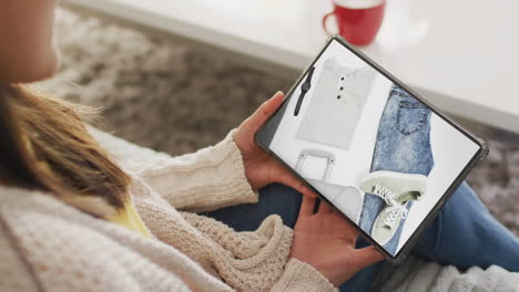 caucasian woman using tablet at home for online shopping, slow motion