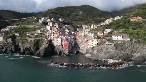 Riomaggiore-Cinque-Terre-Italy-aerial-approaching-city-on-ocean-slowly