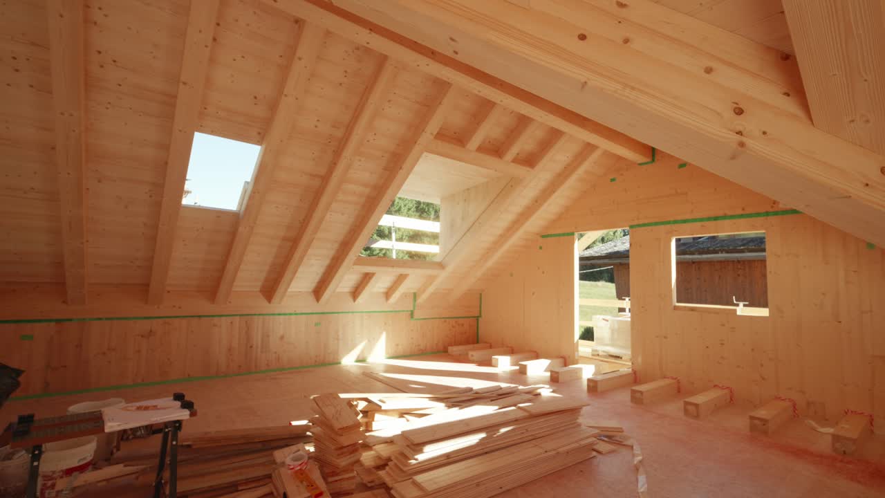 Interior view of unfinished wooden house under construction with warm sunlight coming from outside
