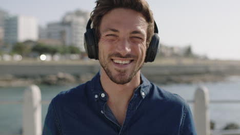 portrait-of-attractive-young-man-laughing-cheerful-enjoying-relaxed-sunny-beachfront-wearing-headphones