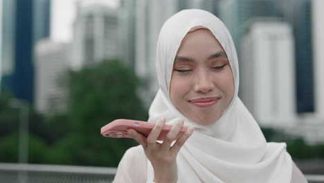 woman in hijab talking on phone in city