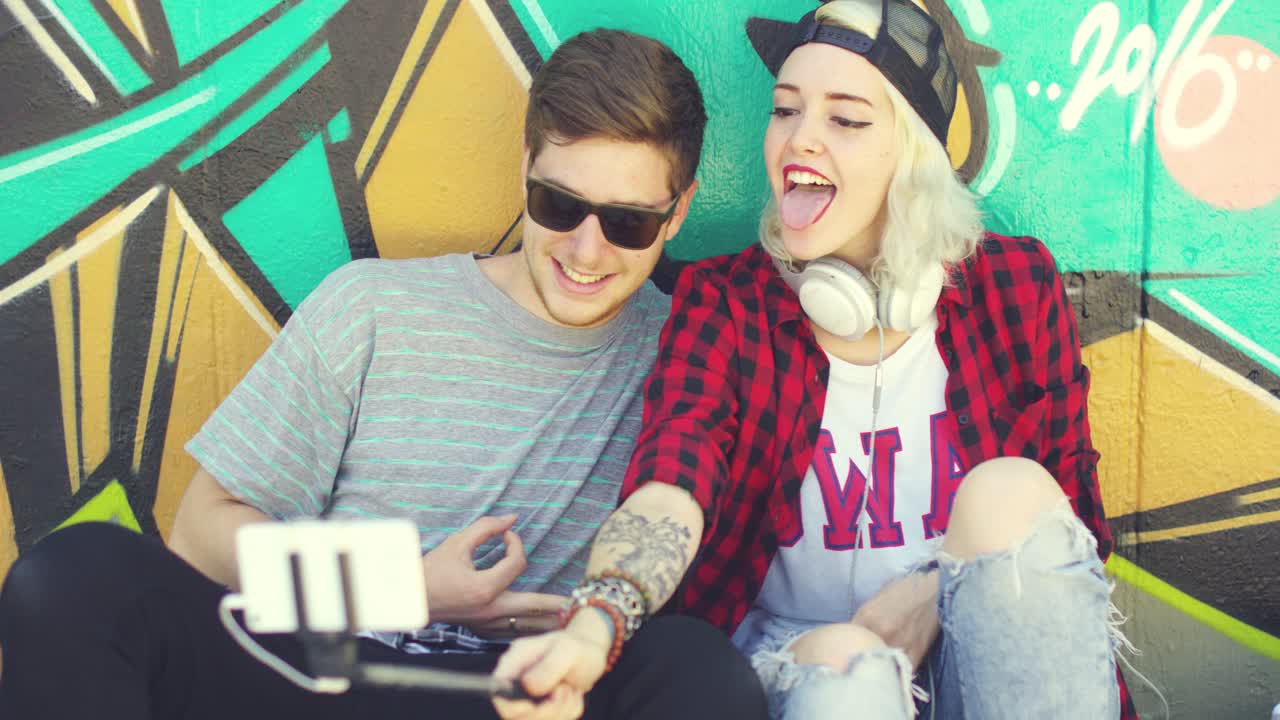 una pareja de jóvenes hipsters de moda tomando una selfie.