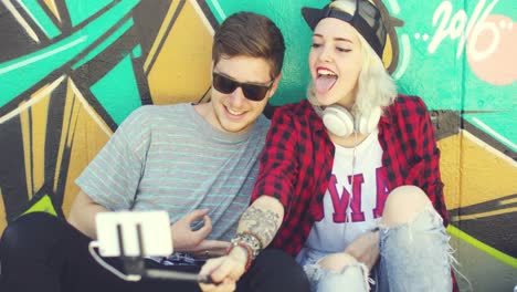 una pareja de jóvenes hipsters de moda tomando una selfie.