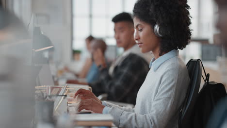 Mujer-De-Negocios-Joven-Que-Usa-Una-Computadora-Escribiendo-En-El-Teclado-Enviando-Correos-Electrónicos-En-Red-En-Una-Oficina-Ocupada-Usando-Audífonos