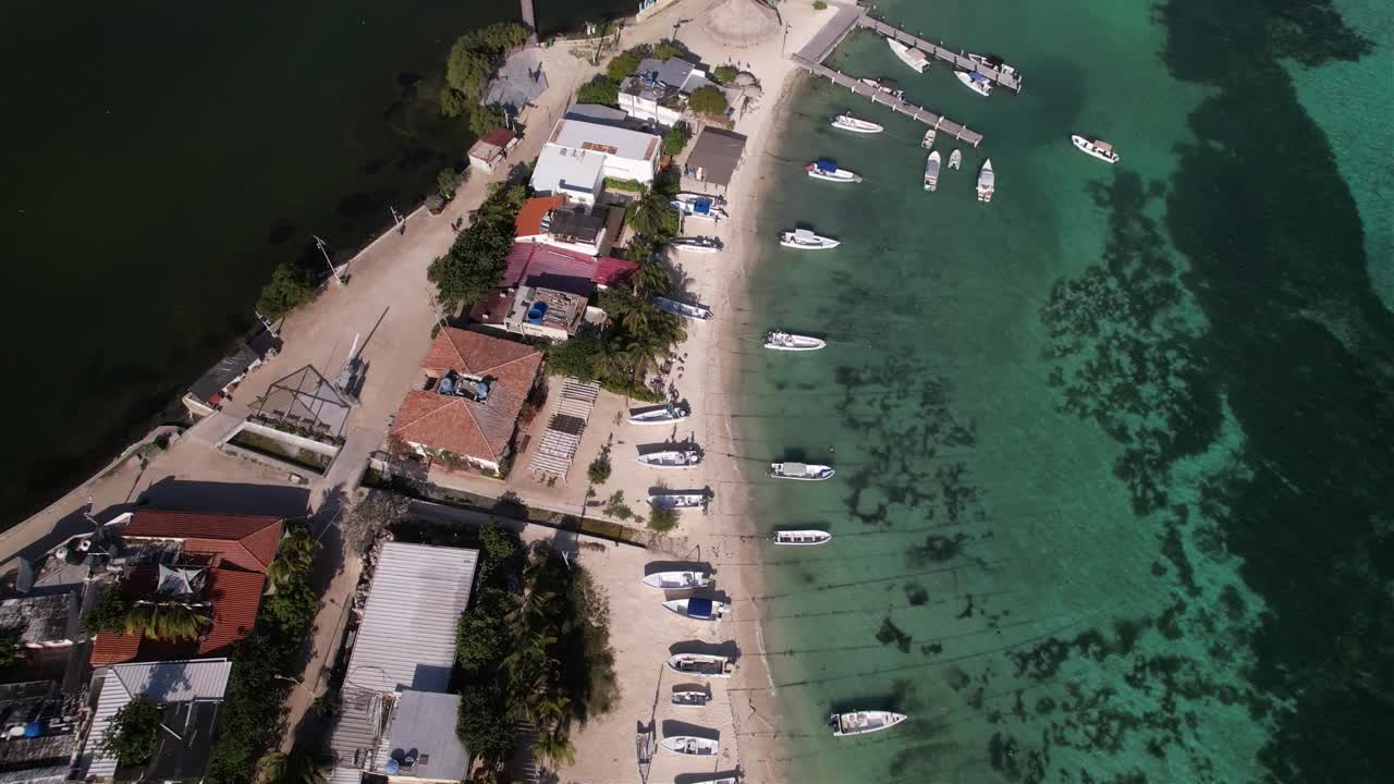 Aerial zenith view tilt up reveal Caribbean airport and pier on Los Roques island