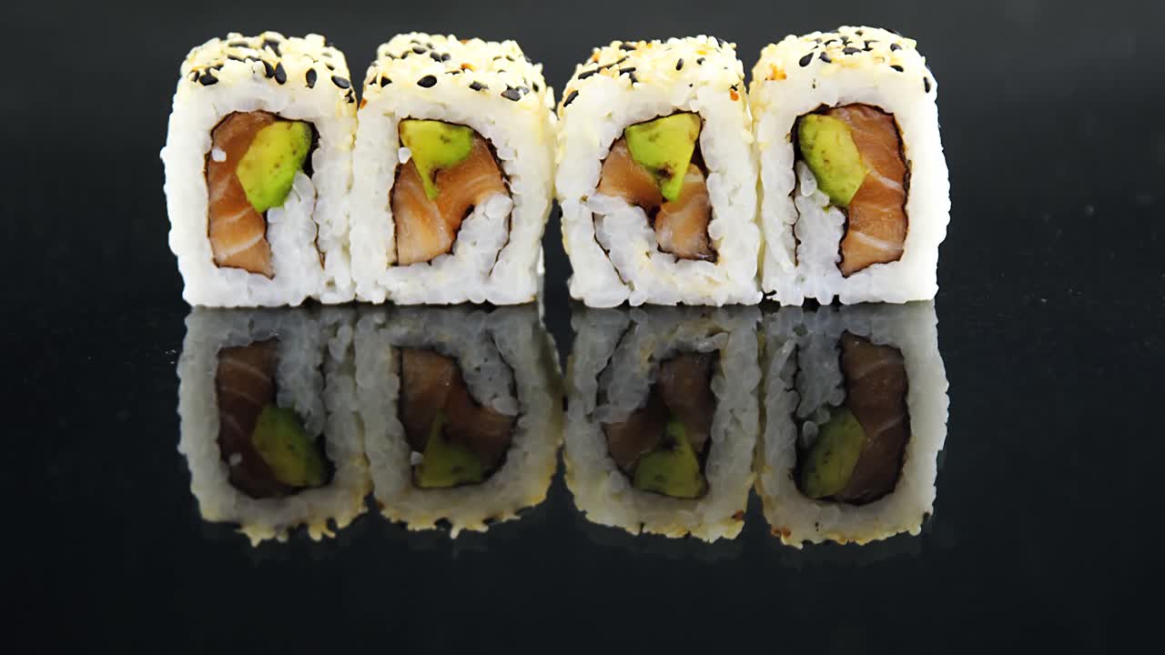 sushi de uramaki sobre un fondo negro