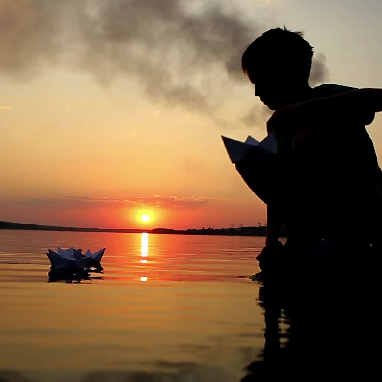 niño lanzando un barco de papel