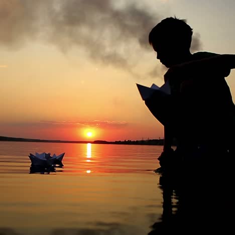 boy launching paper boat