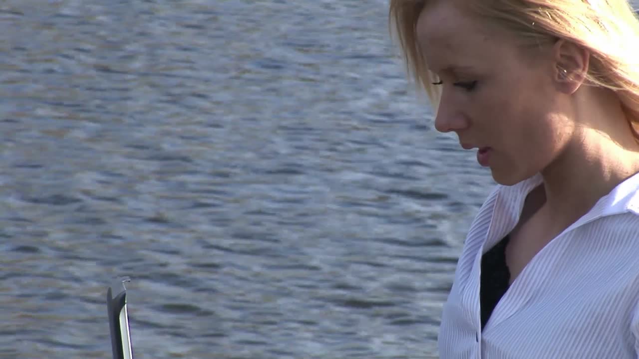 야외에서 노트북을 사용하는 젊은 매력적인 금발 여성