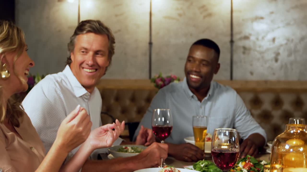 amigos sonriendo y hablando en una fiesta de cena 4k