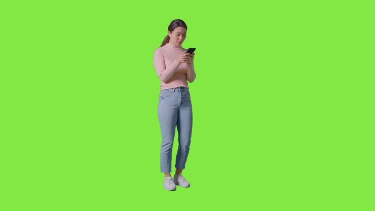 Full Length Studio Shot Of Woman Checking Mobile Phone And Getting Disappointing News Message Against Green Screen