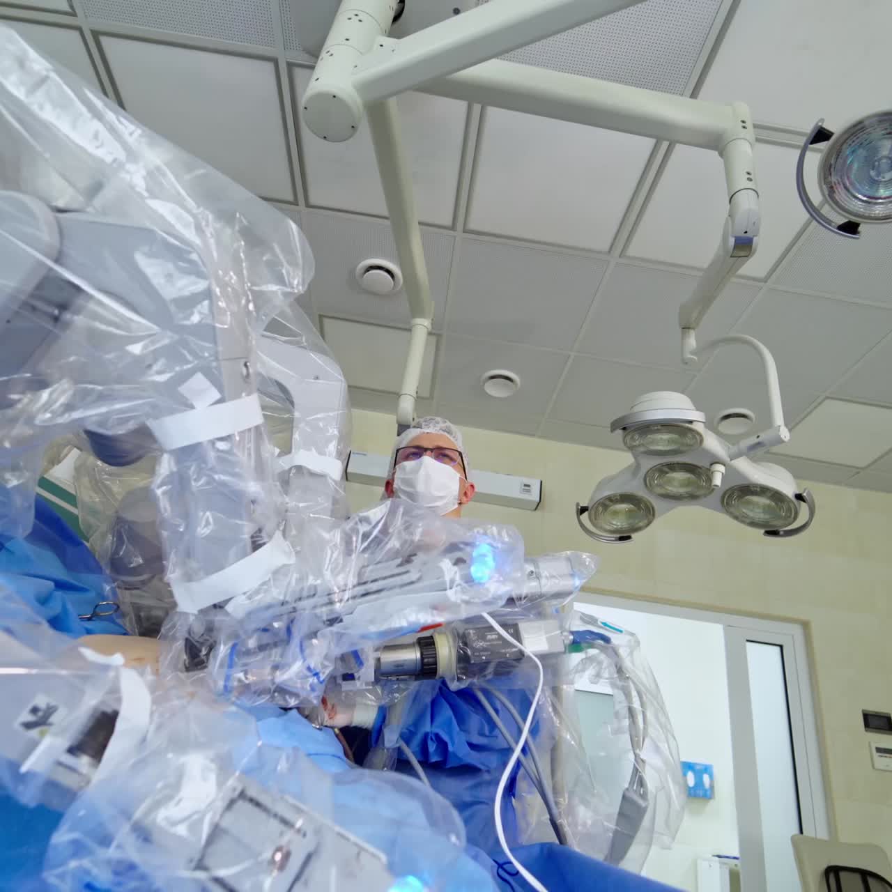 Performing robotic surgery in hospital. Medical assistant working with the medical technology equipment