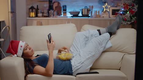 woman browsing internet on smartphone and watching television