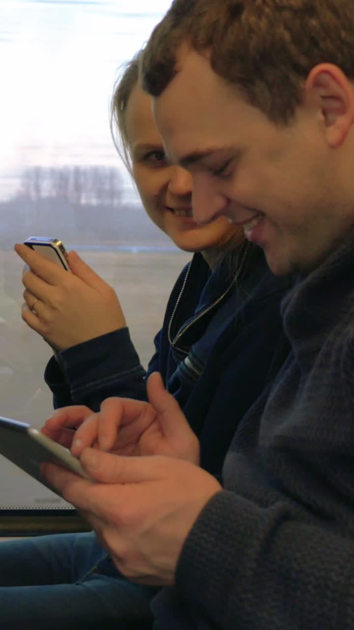 People using smartphones on a train