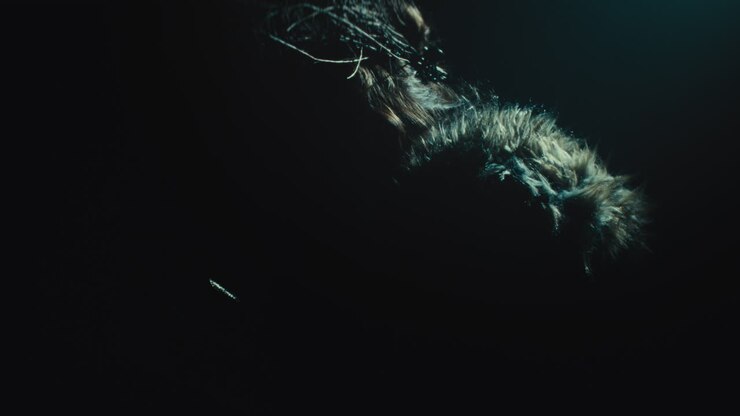 A creepy witch stands in the moody pose during the night storm