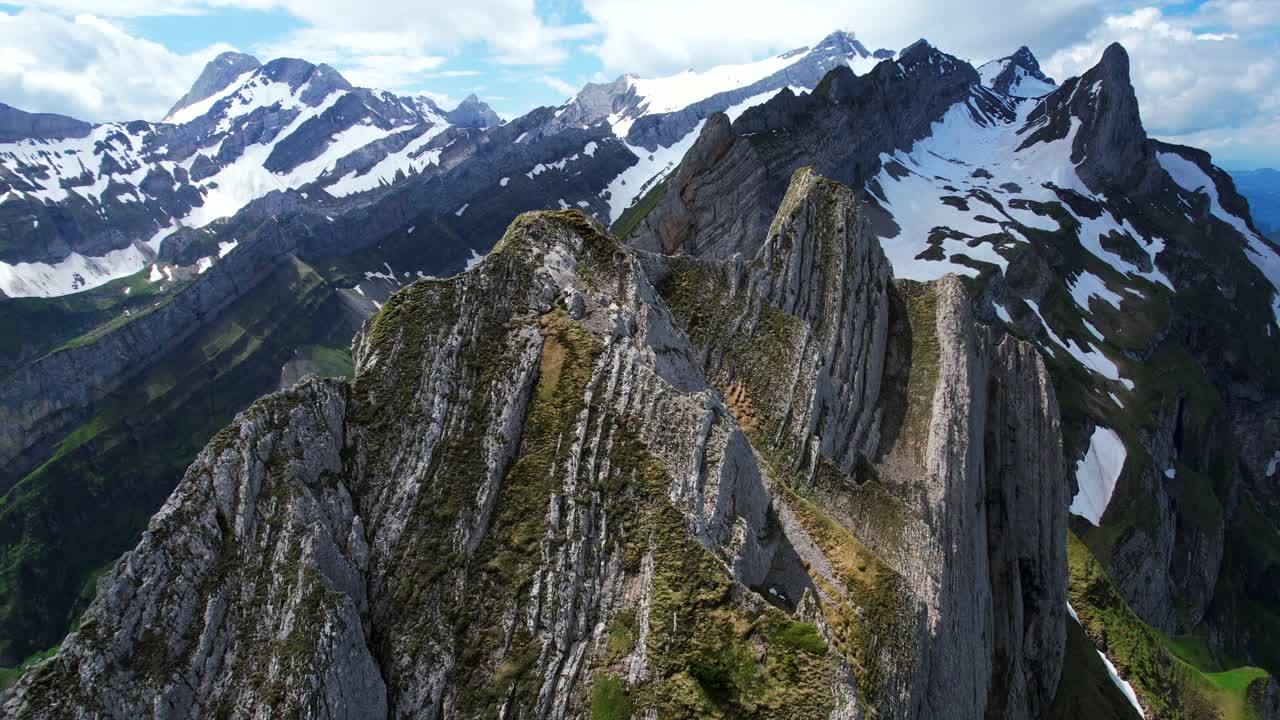 tomada aérea de un avión no tripulado de 4k desde la cima de los picos rocosos dentados en la cresta de schaeffler en la región de apenzell de suiza