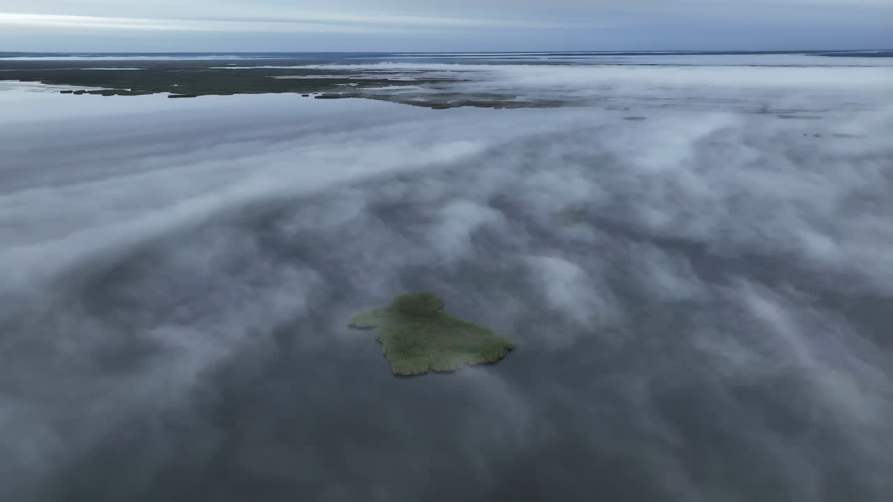 Aerial View of Misty Wetlands with Small Green Island